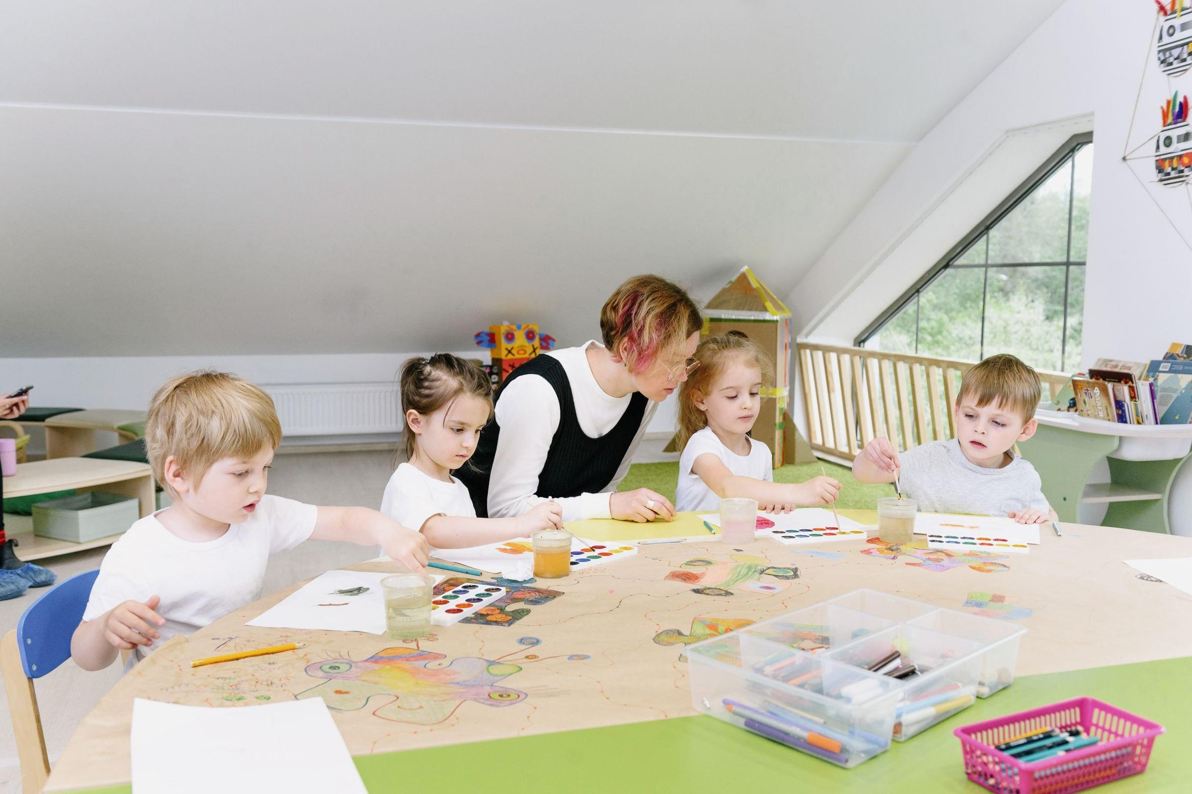 Niños pintando y aprendiendo junto a su docente